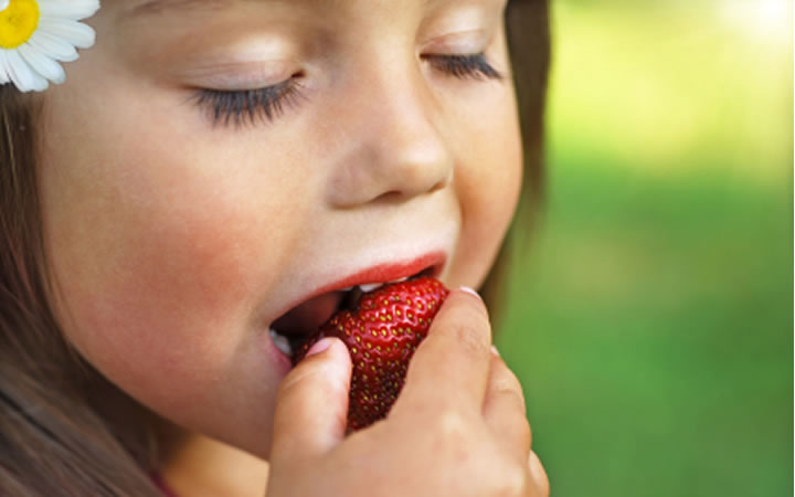 Kind isst Erdbeere